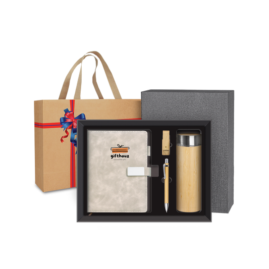 Gift set with notebook, pen, and tumbler in a box with a gift bag and bow on a white background
