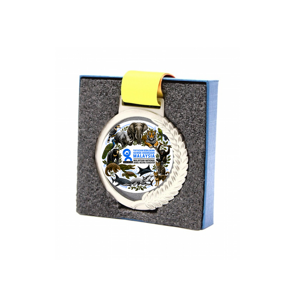 A round silver-toned Malaysian national emblem medallion with a yellow ribbon, presented in a gray foam insert box with blue sides on a white background.