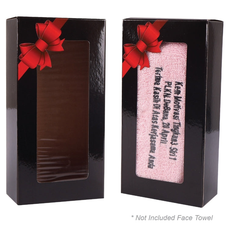 Two black gift boxes with red bows, one containing a brown face towel and the other a pink face towel with text.
